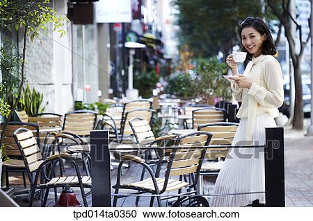 Stock Image - leaning, day, daytime, cafe, Asian, tea, person. Fotosearch