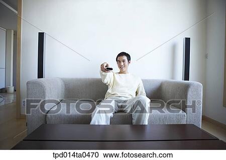 sitting, remote control, inside, sofa, person, Asian View Large Photo Image Stock Image - sitting, remote control, inside, sofa, person, Asian. Fotosearch