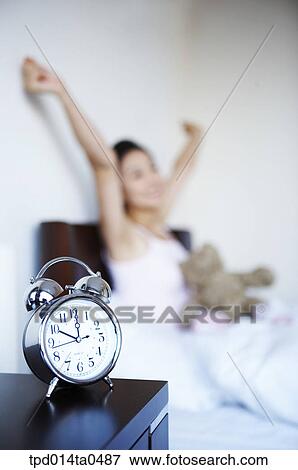 Stock Photo - stretching, Asian, person, clock, inside, morning, alarm clock. Fotosearch