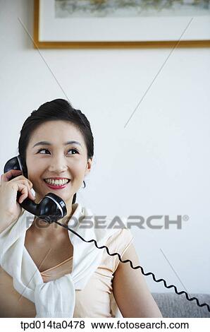Stock Photo - telephone, person, smile, woman, inside, young lady, Asian. Fotosearch