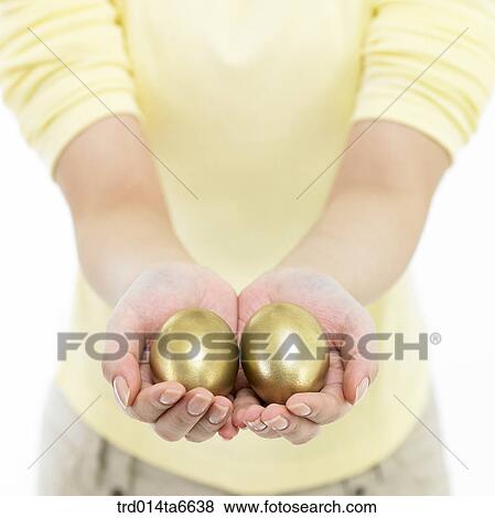 Stock Photo - person, body, hand, closeup, object, golden egg, egg. Fotosearch