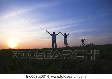 Picture - a couple's silhouette in a glow. Fotosearch