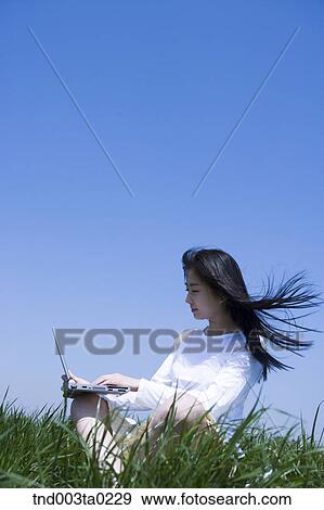 Stock Photo - a woman doing something with a notebook. Fotosearch