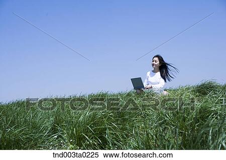 a woman doing something with a notebook View Large Photo Image Stock Photography - a woman doing something with a notebook. Fotosearch
