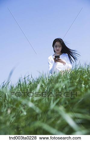 a woman doing something with a PDA View Large Photo Image Stock Photo - a woman doing something with a PDA. Fotosearch