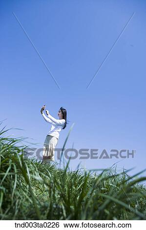 a woman doing something with a PDA View Large Photo Image Stock Photograph - a woman doing something with a PDA. Fotosearch