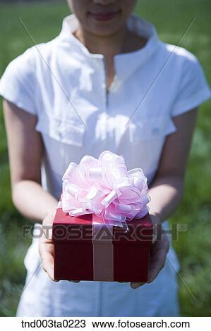 Stock Image - a woman giving a present . Fotosearch