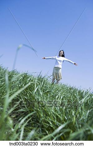 Stock Image - a woman listening to music with a headset. Fotosearch