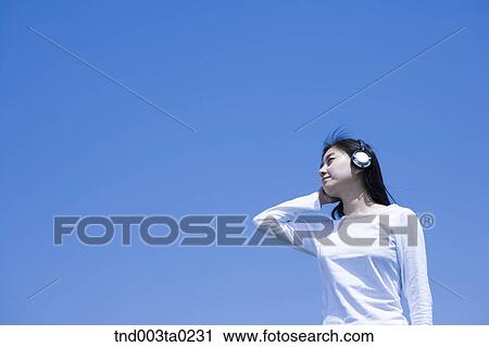 a woman listening to music with a headset View Large Photo Image Stock Image - a woman listening to music with a headset. Fotosearch