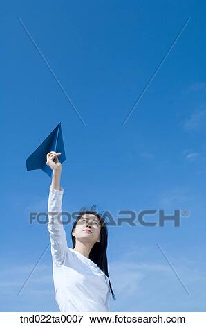a woman playing with a paper airplane View Large Photo Image Stock Photo - a woman playing with a paper airplane. Fotosearch