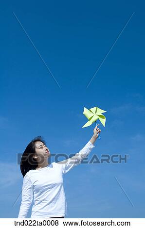 a woman playing with a toy pinwheel View Large Photo Image Stock Photo - a woman playing with a toy pinwheel. Fotosearch