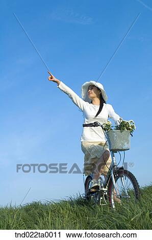 a woman riding a bicycle on the grass View Large Photo Image Stock Image - a woman riding a bicycle on the grass. Fotosearch