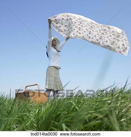 a woman unfolding a mat in the grass View Large Photo Image Stock Image - a woman unfolding a mat in the grass. Fotosearch