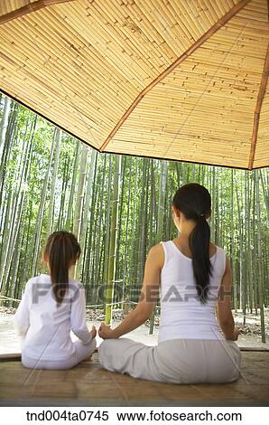 a mother and a child doing Yoga at a pavilion in a bamboo tree forest View Large Photo Image Stock Photography - a mother and a child doing Yoga at a pavilion in a bamboo tree forest. Fotosearch