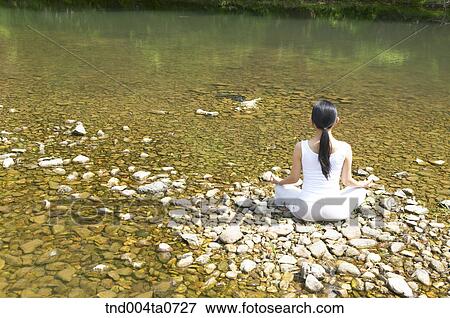 Stock Photo - a woman doing Yoga in a flower garden. Fotosearch