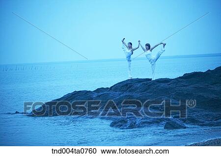a woman doing Yoga on the rock in a seashore View Large Photo Image Stock Image - a woman doing Yoga on the rock in a seashore. Fotosearch
