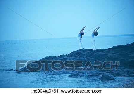 a woman doing Yoga on the rock in a seashore View Large Photo Image Stock Image - a woman doing Yoga on the rock in a seashore. Fotosearch