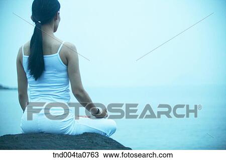 a woman doing Yoga on the rock in a seashore View Large Photo Image Stock Image - a woman doing Yoga on the rock in a seashore. Fotosearch