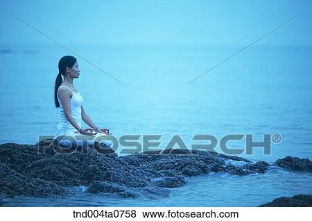 a woman doing Yoga on the rock in a seashore View Large Photo Image Stock Photo - a woman doing Yoga on the rock in a seashore. Fotosearch