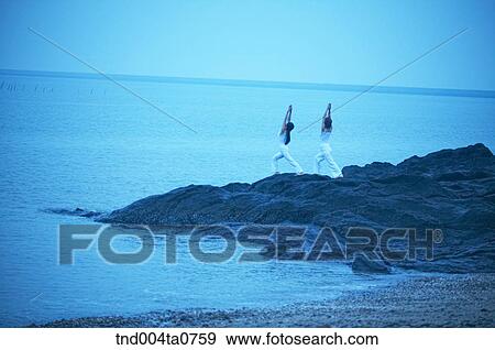 a woman doing Yoga on the rock in a seashore View Large Photo Image Stock Photo - a woman doing Yoga on the rock in a seashore. Fotosearch