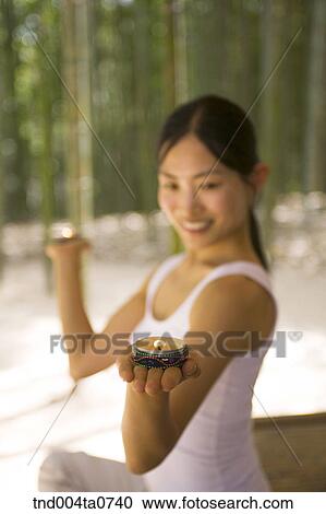 a woman holding aromatic candles in a bamboo tree forest View Large Photo Image Stock Image - a woman holding aromatic candles in a bamboo tree forest. Fotosearch
