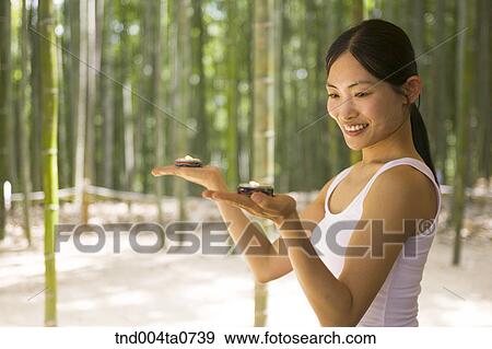 a woman holding aromatic candles in a bamboo tree forest View Large Photo Image Stock Photo - a woman holding aromatic candles in a bamboo tree forest. Fotosearch