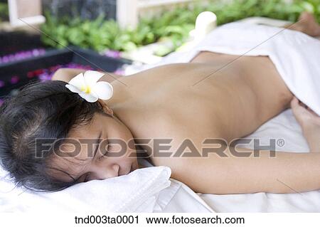 Stock Image - spa/ a woman lying on a massage table. Fotosearch