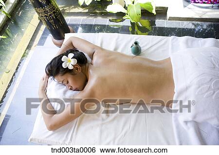 spa/ a woman lying on a massage table View Large Photo Image Stock Photograph - spa/ a woman lying on a massage table. Fotosearch