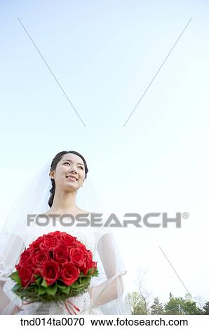 Stock Image - Wedding, a bride holding a bouquet. Fotosearch