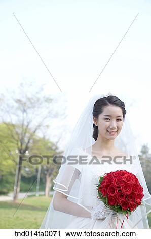 Stock Image - Wedding, a bride holding a bouquet. Fotosearch