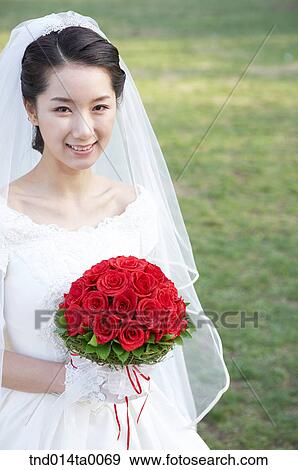 Stock Photo - Wedding, a bride holding a bouquet. Fotosearch