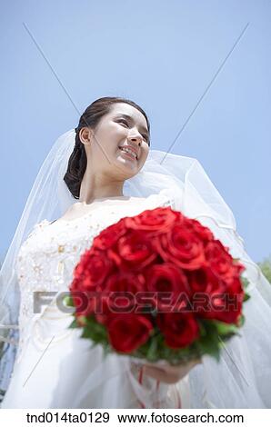 Wedding, a bride holding a bouquet View Large Photo Image Stock Photo - Wedding, a bride holding a bouquet. Fotosearch