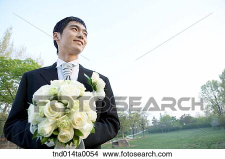 Wedding, a bridegroom holding a bouquet View Large Photo Image Picture - Wedding, a bridegroom holding a bouquet. Fotosearch