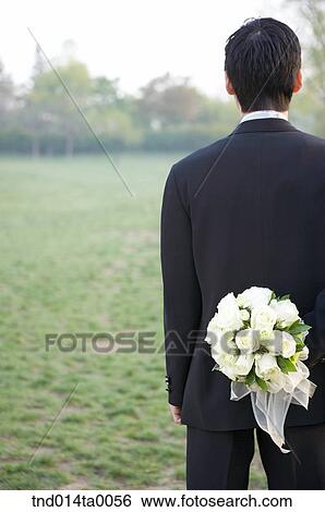 Wedding, a bridegroom holding a bouquet View Large Photo Image Stock Photograph - Wedding, a bridegroom holding a bouquet. Fotosearch