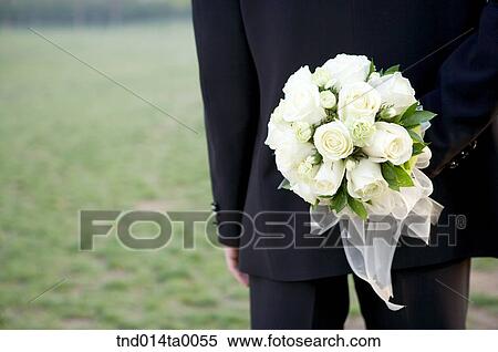 Wedding, a bridegroom holding a bouquet View Large Photo Image Stock Photography - Wedding, a bridegroom holding a bouquet. Fotosearch