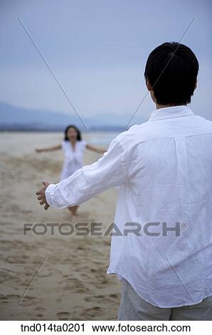 Stock Image - couple coming with stretched arms. Fotosearch