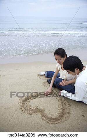 couple drawing hear on the sand View Large Photo Image Stock Photography - couple drawing hear on the sand. Fotosearch