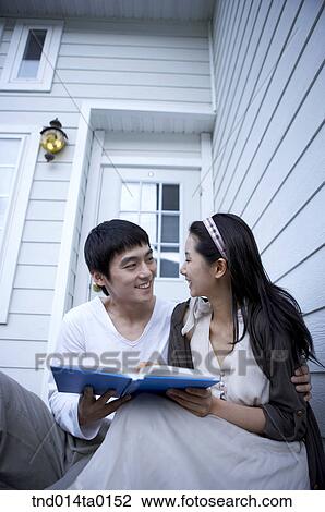 Stock Image - couple looking at books and chat . Fotosearch