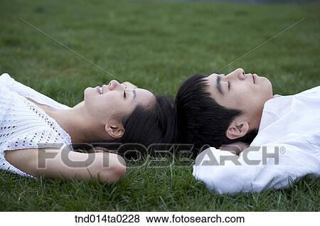 Stock Photo - couple sleeping on the grass. Fotosearch
