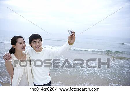 Stock Photo - couple taking picutre with thier digital camera. Fotosearch