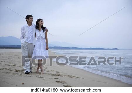 couple walking on the seashore View Large Photo Image Stock Image - couple walking on the seashore. Fotosearch