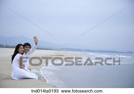couple with hand up on the seashore View Large Photo Image Stock Image - couple with hand up on the seashore. Fotosearch