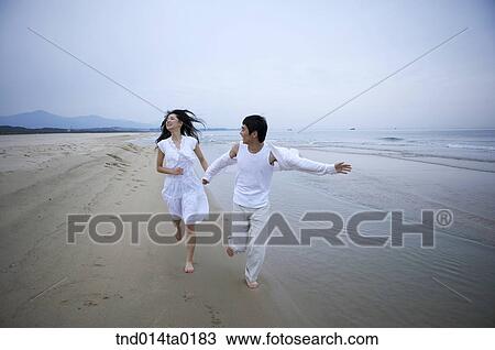 happy couple running on the seashore View Large Photo Image Stock Image - happy couple running on the seashore. Fotosearch