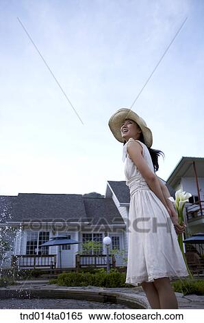 happy woman holding flower in front of fountain View Large Photo Image Stock Photography - happy woman holding flower in front of fountain. Fotosearch