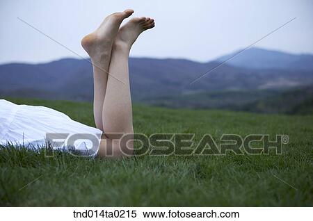 Stock Photography - leg of woman who laying down the grass. Fotosearch