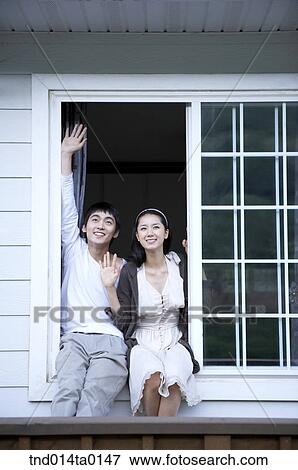 Stock Photo - Newly married couple sitting on ther pane and waving their hands. Fotosearch
