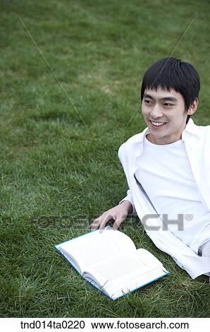 Stock Image - rest, grass field?? booklooking man. Fotosearch