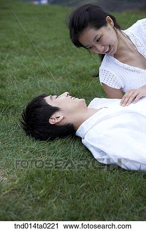 Stock Image - woman chatting on the grass. Fotosearch