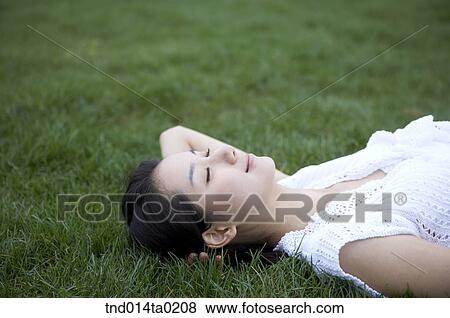 Stock Photo - woman laying on the grass. Fotosearch
