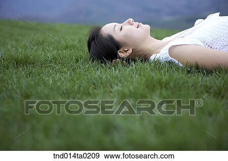 Stock Photo - woman laying on the grass. Fotosearch